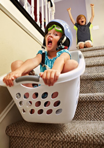 Girl going down stairs in laundry basket